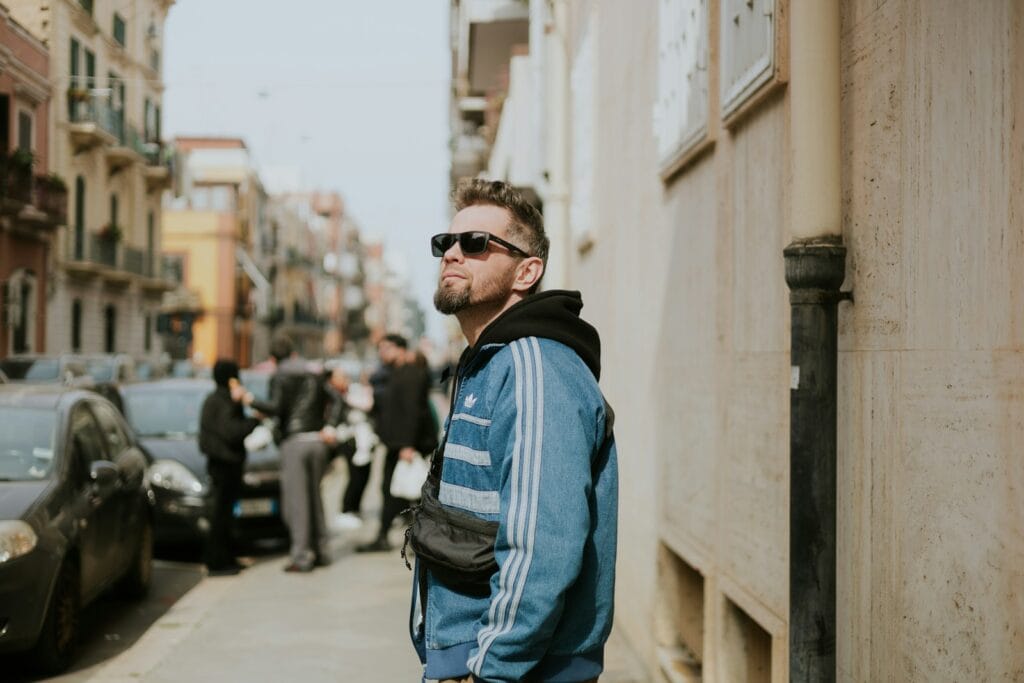 Man in sunglasses and blue jacket on city street