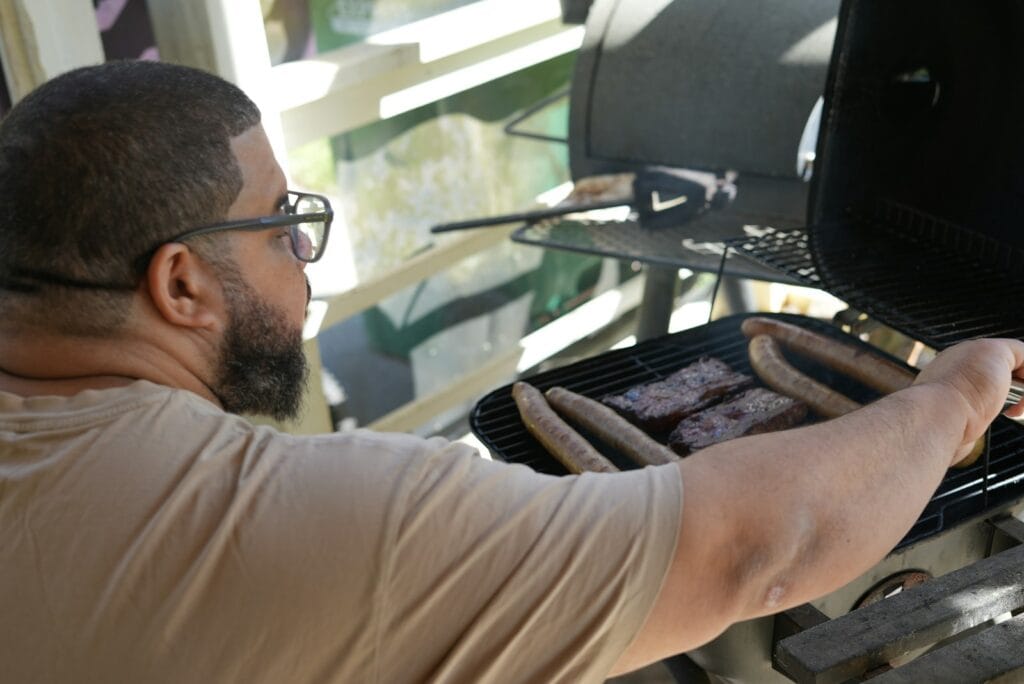 a man is grilling hot dogs on a grill