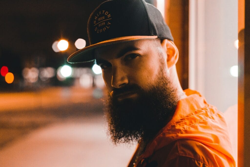 man in black and white fitted cap and orange jacket