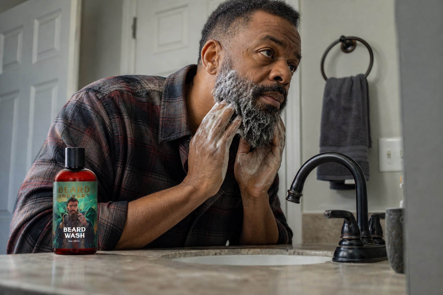 Man washing his beard at the bathroom sink with Beard Sorcery Beard Wash on the counter